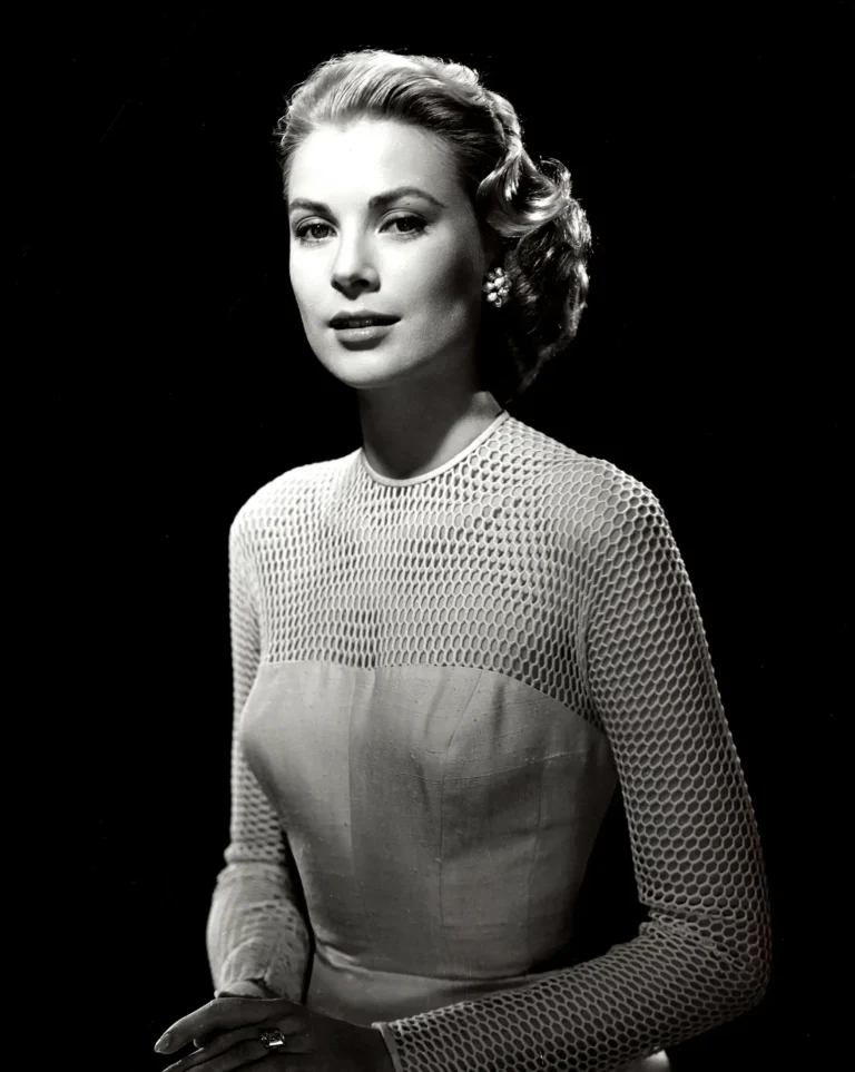 Grace Kelly studio poster showing a 1955 portrait with mesh sleeves and a pale bodice.