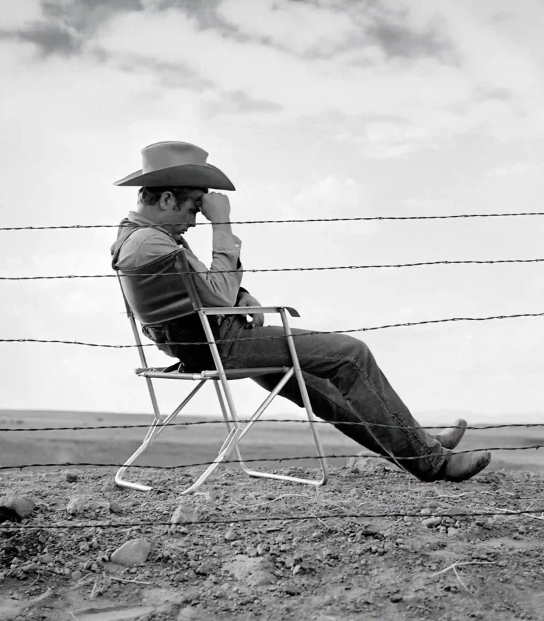 James Dean cowboy poster from Giant showing him seated behind barbed wire in a hat.