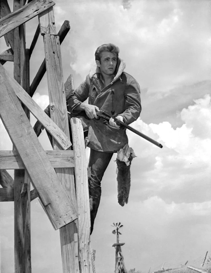 James Dean hunting poster from Giant showing him with rifle on a wooden structure.