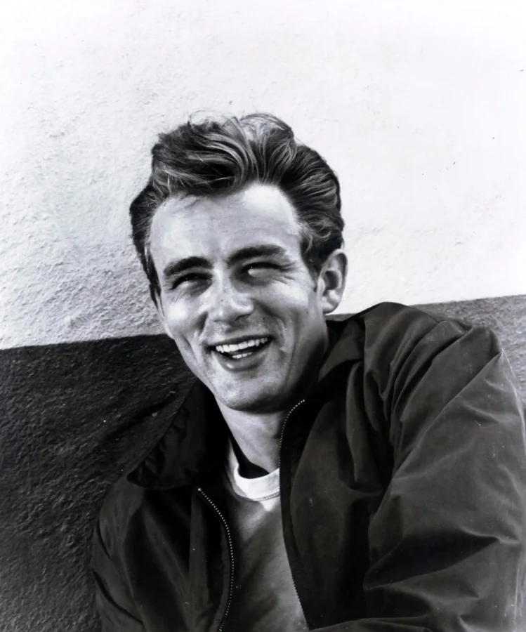 James Dean smiling poster showing a casual 1950s black and white portrait.