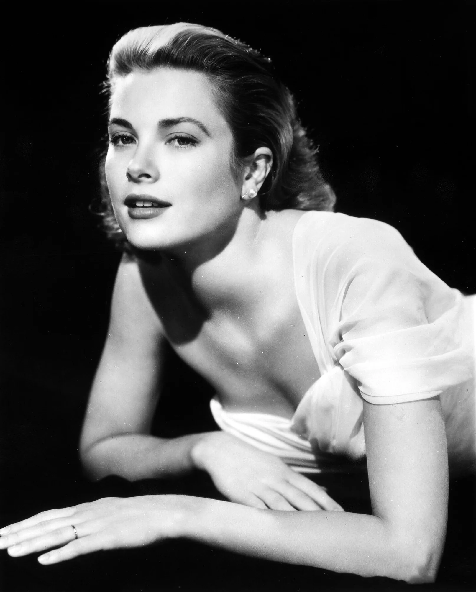 Grace Kelly thief poster showing a reclining black-and-white studio pose in a white dress.