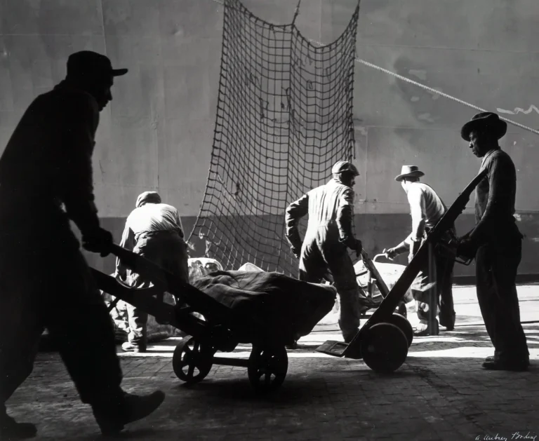 A. Aubrey Bodine poster showing longshoremen at work in a 1955 harbor photograph.