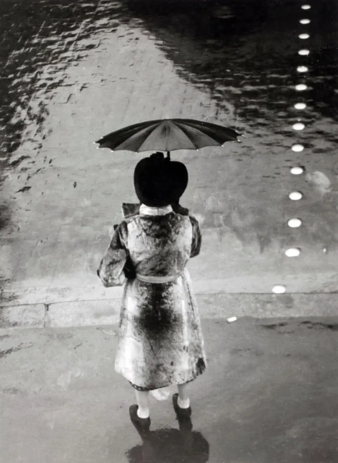 Brassai poster showing a woman with an umbrella on Rue de Rivoli in 1937.
