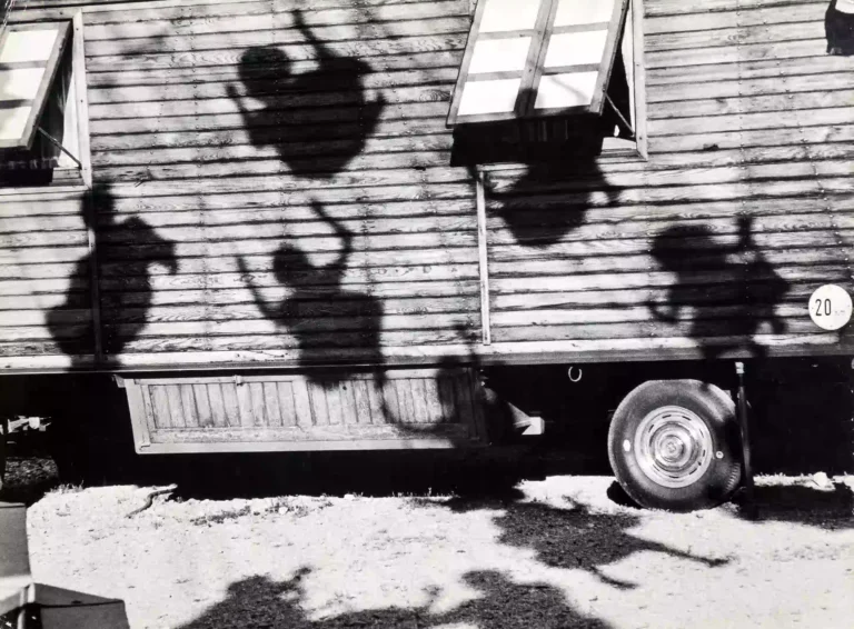 Clean artwork view of Jon Naar Shadows of Children on Swings Munich 1963 Photography Print. Shadows Children Photography Print presents Shadows of Children on Swings Munich 1963 by Jon Naar, a black-and-white image from 1963 shaped by clear.
