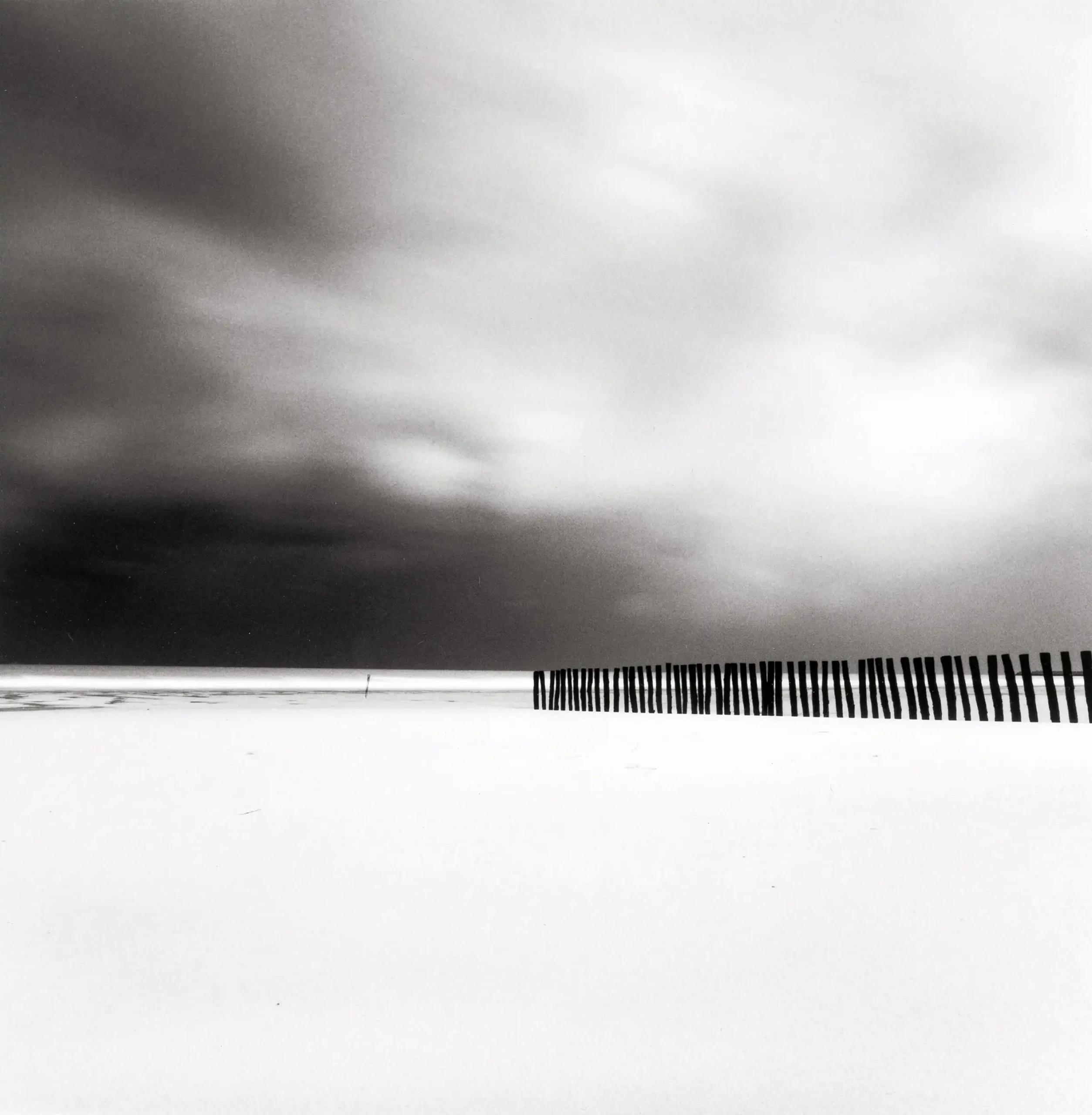 Michael Kenna poster showing fifty-four sticks arranged on the Calais shore.