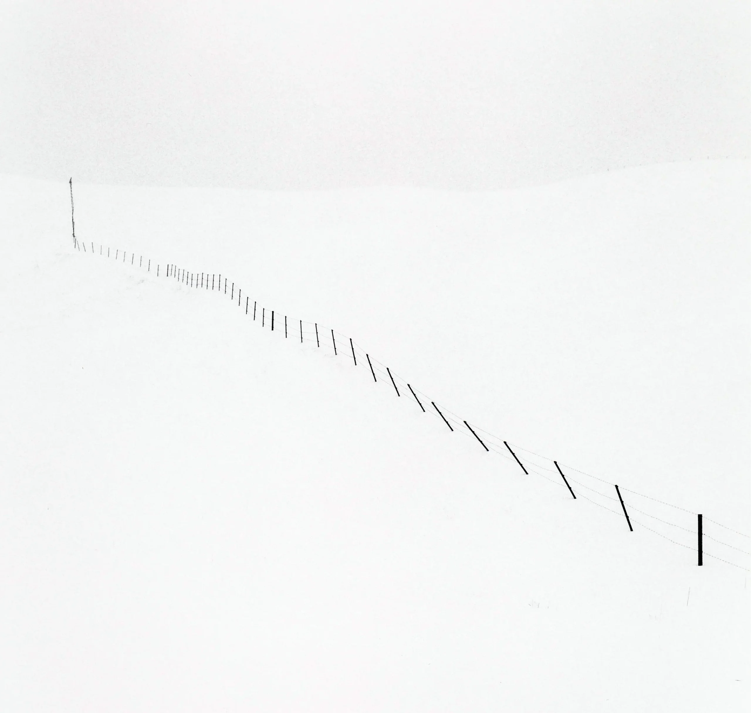 Michael Kenna poster showing a sparse Hokkaido hillside fence in winter-like quiet.