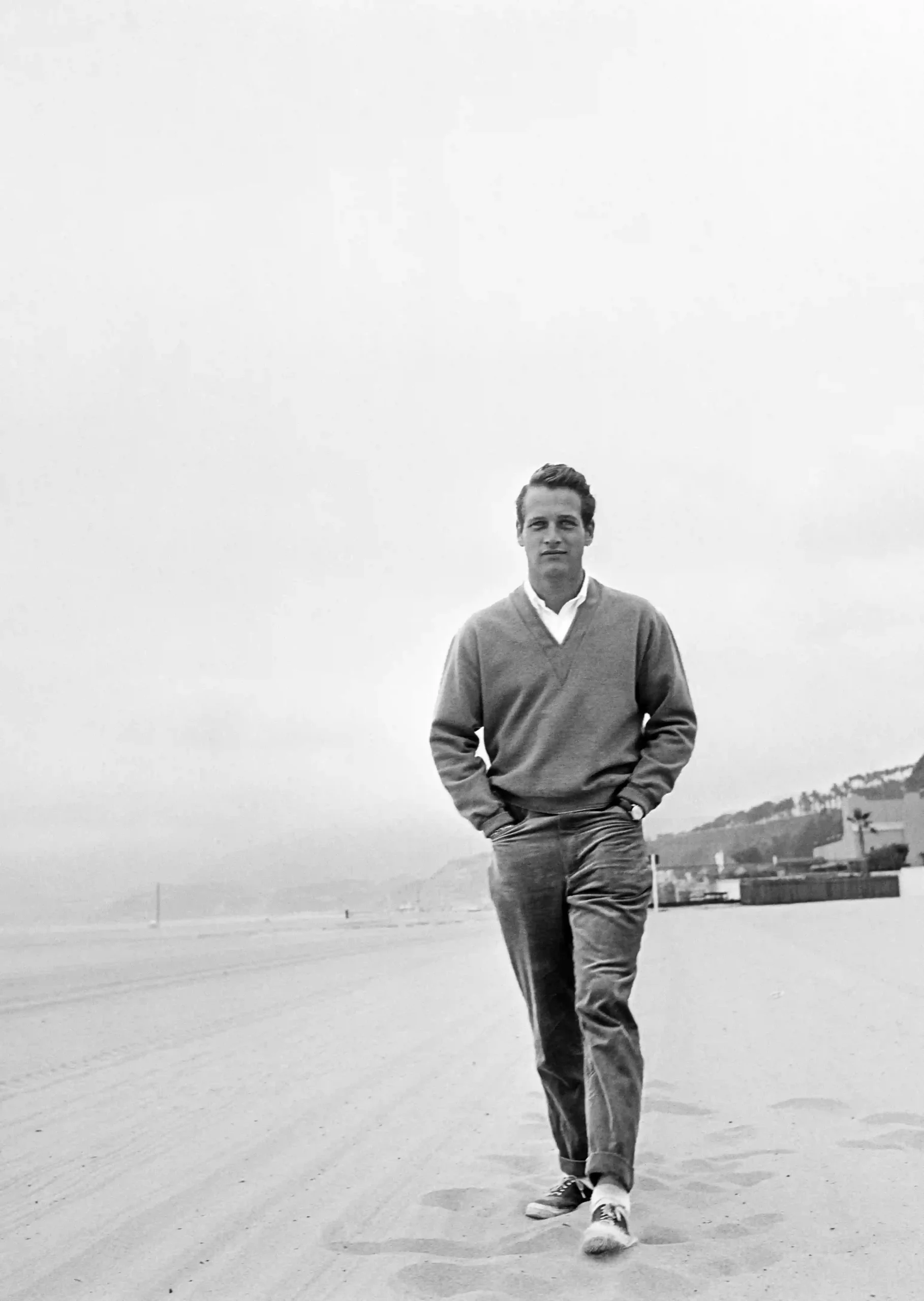Paul Newman Beach Walk — paul Newman walks along an open shoreline in a sweater and cuffed